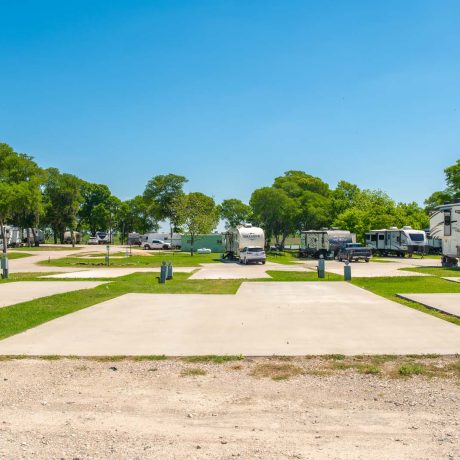 parked camper trailers and empty RV spaces at Lost River RV Park with grassy lots and clean concrete rv spaces