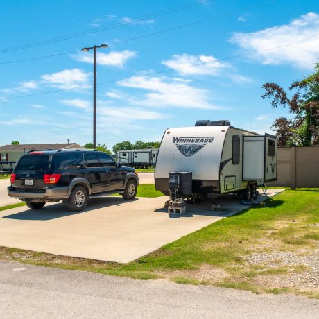 parked car and trailer at Lost River RV Park with grassy lots and clean concrete rv spaces